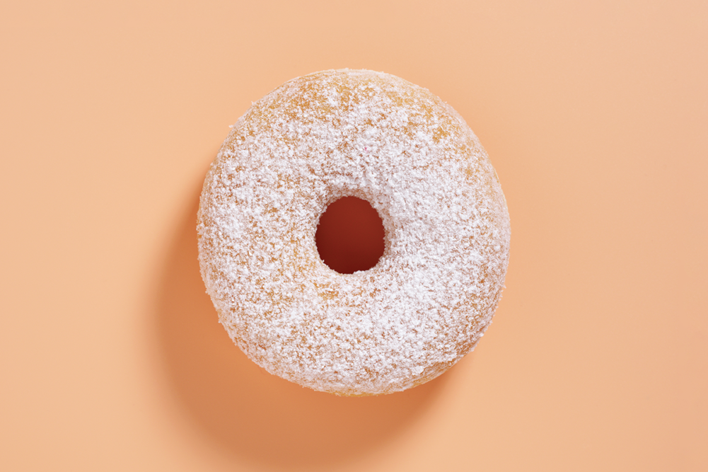 powdered donut on peach background