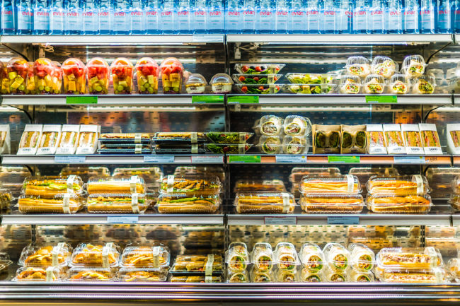 Pre-packaged sandwiches, salads and drinks displayed in a commercial refrigerator
